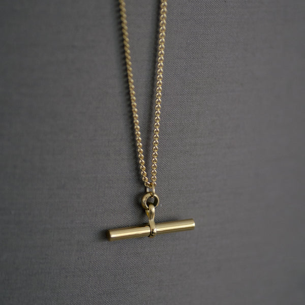 Charlotte 18K gold plated stainless steel necklace with bar pendant on a soft gray background