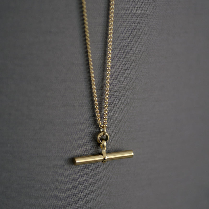 Charlotte 18K gold plated stainless steel necklace with bar pendant on a soft gray background