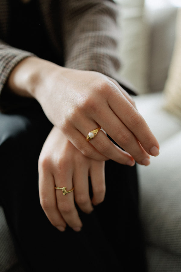 La Perle ring in 18k gold plated brass with pearl accent on brown suede background