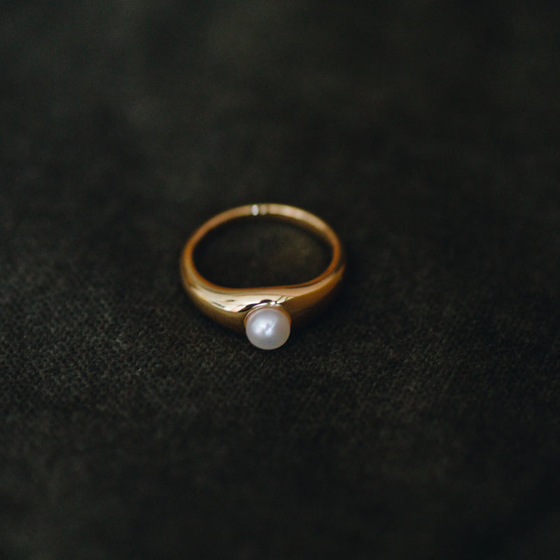 La Perle ring in 18k gold plated brass with pearl accent on brown suede background