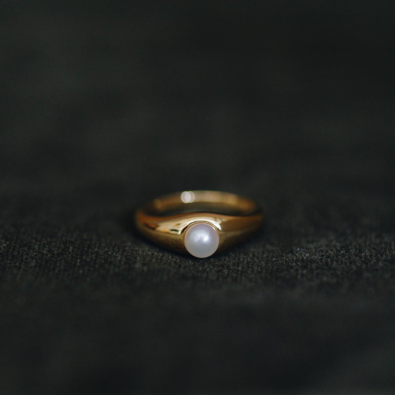 La Perle ring in 18k gold plated brass with pearl accent on brown suede background
