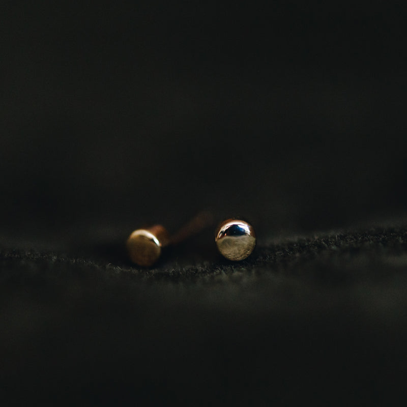 Close-up of Soleil 14K solid gold round stud earrings – minimalist 3mm everyday style