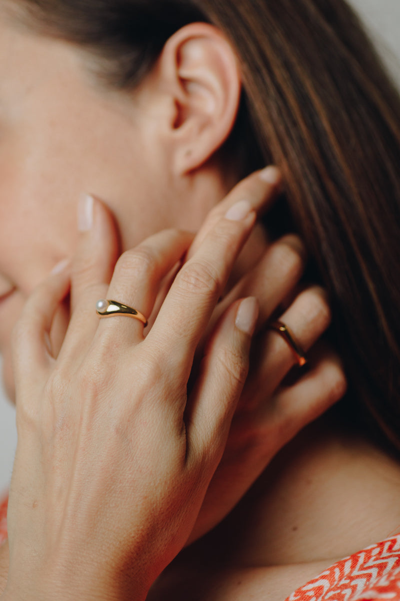 La Perle ring in 18k gold plated brass with pearl accent on brown suede background