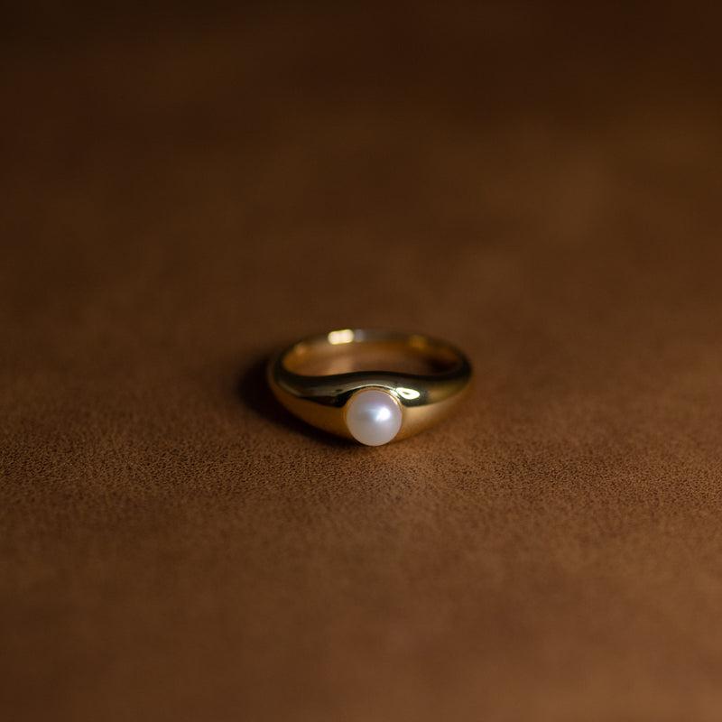 La Perle ring in 18k gold plated brass with pearl accent on brown suede background