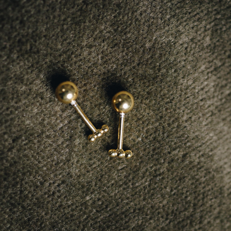 Close-up of Hélène dainty gold bar earrings with secure screw-in back