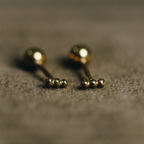 Close-up of Hélène dainty gold bar earrings with secure screw-in back