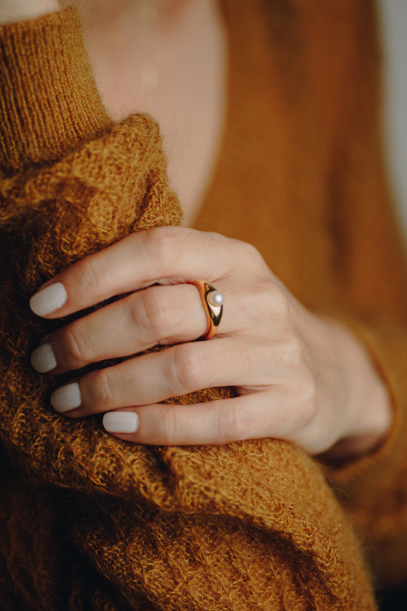La Perle ring in 18k gold plated brass with pearl accent on brown suede background